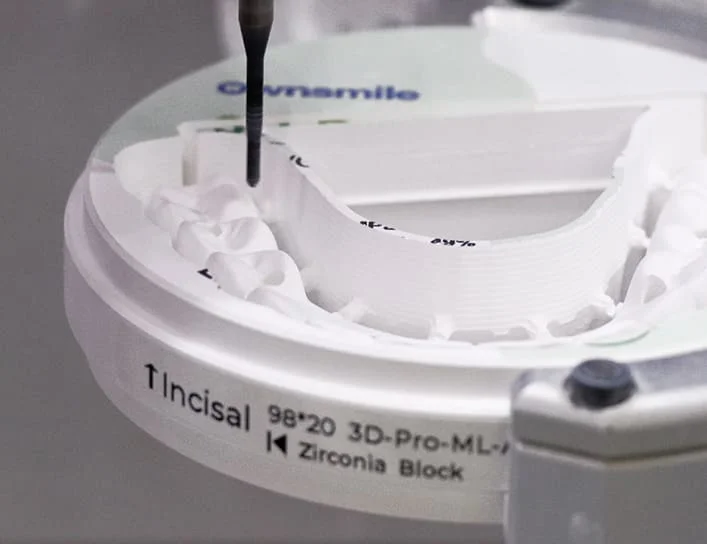 Dental milling machine calibrating tool position on zirconia block for precise cutting