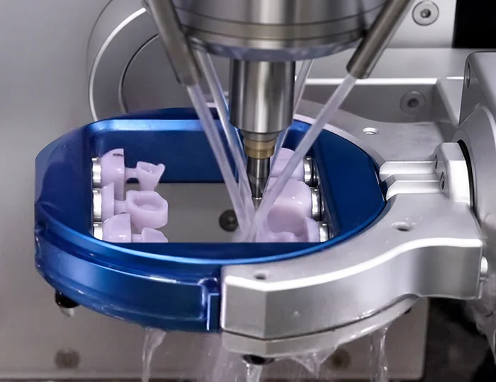 Wet dental milling machine cutting a glass ceramic block